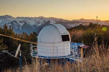 Small astronomical observatory with telescope in Caucasian mountains at the sunset