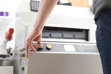 Drukarz. Pracownik obsługuje maszynę drukującą.
