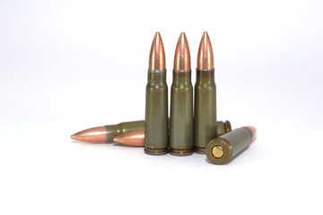 Six rounds of ammunition for Kalashnikov on white background close-up, scattered