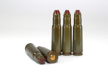 Five blank cartridges for Kalashnikov assault rifles on white background close-up, scattered