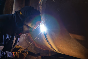 Obraz na płótnie Canvas Welding works on metal heat exchanger using manual arc welding
