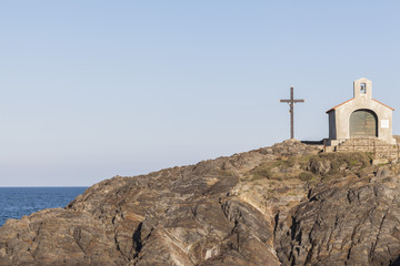 Ancient chapel and cross, rock formation and sea, Collioure, Cote Vermeille, Occitanie, France.