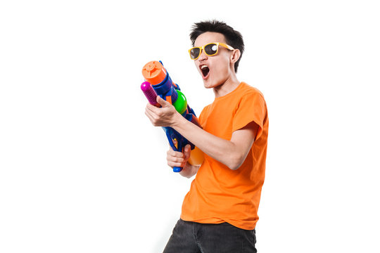 Young man holding water gun on white background.