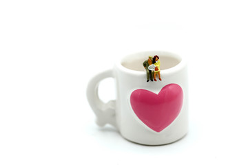 Miniatures people : sitting on a cup of coffee,relax and business concept.