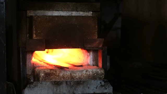 Making the sword out of metal at the forge. Heating of metal billets in the furnace.