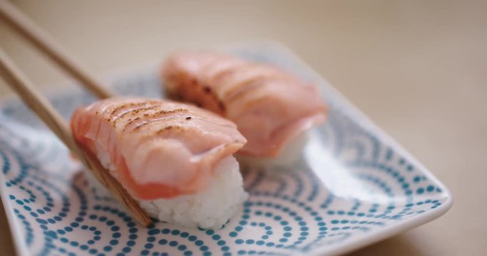 Eating grilled salmon sushi