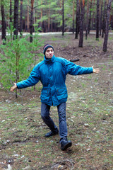 A rural guy posing in a pine forest in the autumn time.