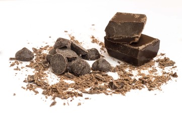chips, drops and pieces of dark chocolate on white background