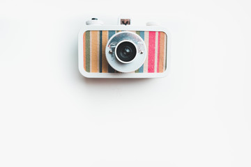 Stylish film camera on a white table, copy space at the bottom