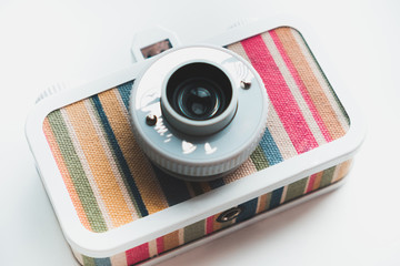 Stylish film camera lies on a white isolated background close-up