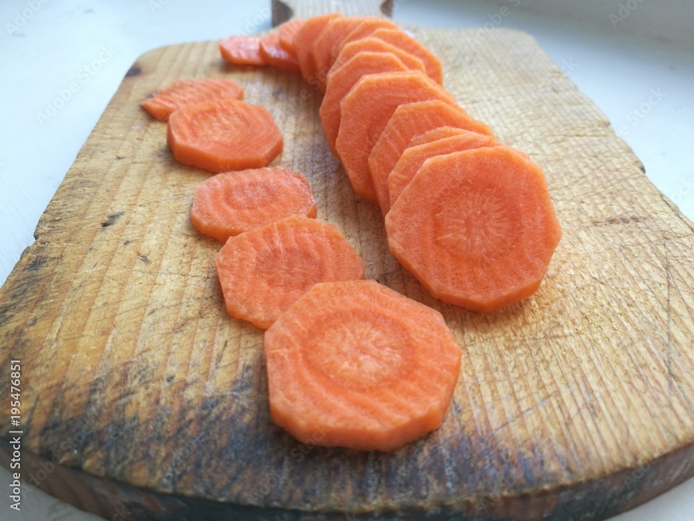 Wall mural Sliced carrot on a cutting board.