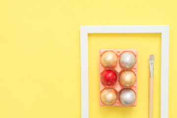 Flat lay top view colorful easter egg painted in pastel colors composition with paint brush on yellow pastel color background. Easter day background top view with copy space.