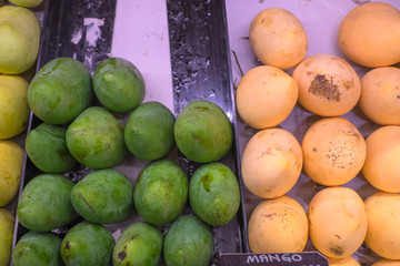 Fresh yellow and green raw manggoes display for sale at market