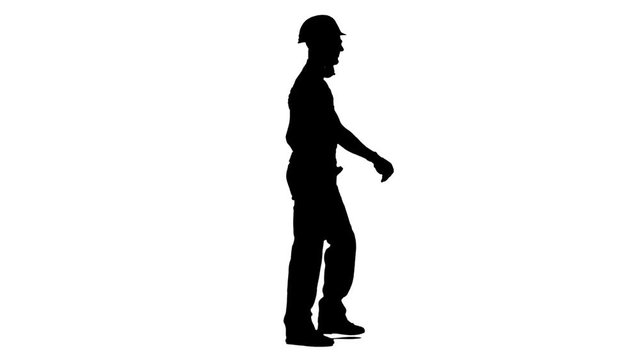 Builder goes to the object with a helmet and tools . White background. Silhouette. Side view