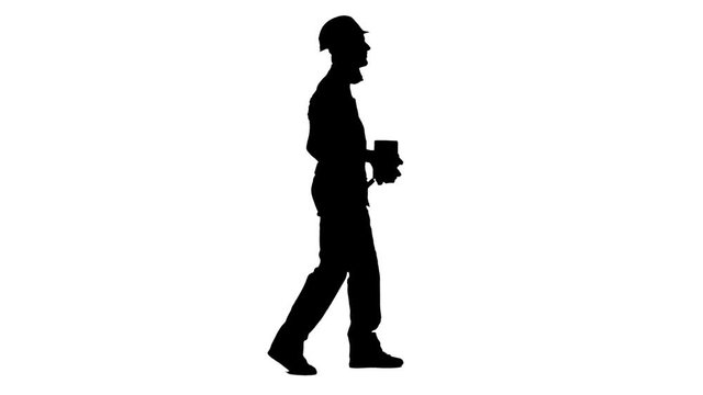 Builder carries in his hands three bricks. White background. Silhouette. Side view