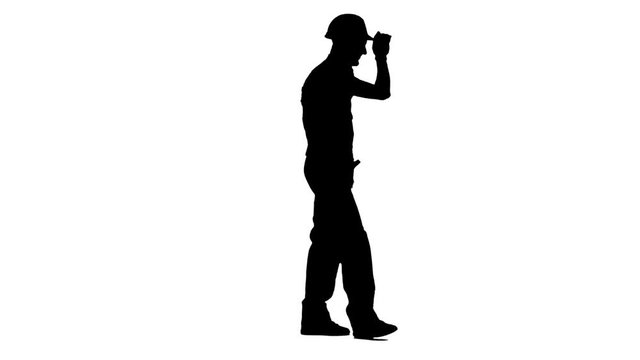 Builder walks and waves to his workers, showing a thumbs up. White background. Silhouette. Side view