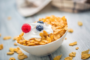 Cornflakes. Dish of cornflakes with yogurt blueberries and raspberries on kitchen table