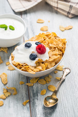 Cornflakes. Dish of cornflakes with yogurt blueberries and raspberries on kitchen table