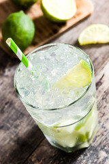 Caipirinha cocktail in glass on wooden table background.