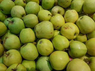 Fresh green apples lie in the shop window

