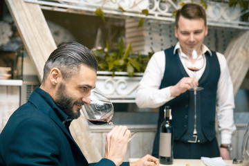 Young men sniffing the glass of a wine