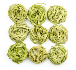 Spinach fettuccine pasta nine raw top view isolated on white background nine pieces.