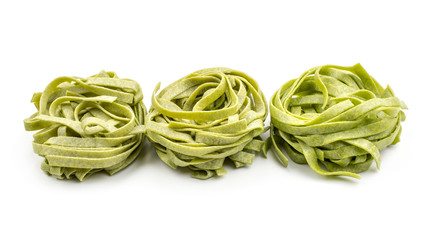 Spinach fettuccine pasta three raw isolated on white background.