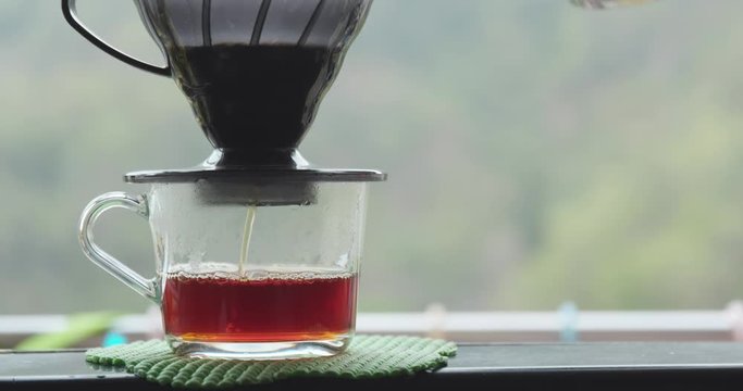 Making drip coffee over green background