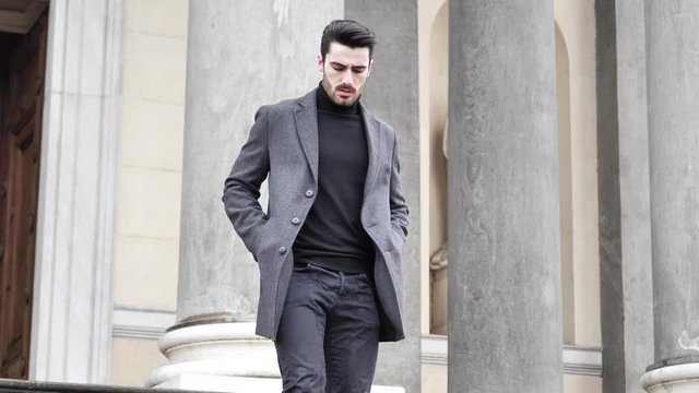 Handsome bearded young man outdoor in winter fashion, wearing black turtleneck sweater and woolen blazer jacket in city setting