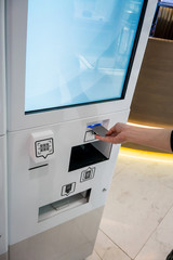 Hand inserting card into the Tax Refund kiosk