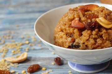 Homemade sweet pongal topped with raisins nuts, selective focus