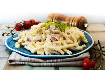 Italian food macaroni gratin with ham on table