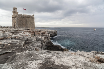 Fototapeta na wymiar Cliffs and Castle or tower, Castell San Nicolau in balearic town of Ciutadella, Minorca island, Balearic islands, Spain.