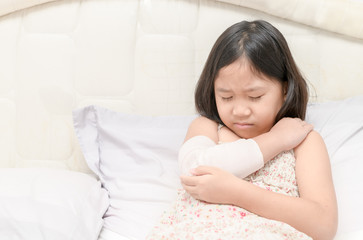 Obraz na płótnie Canvas Little girl with her damaged right arm