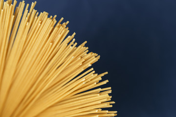 Uncooked pasta spaghetti on a blue background