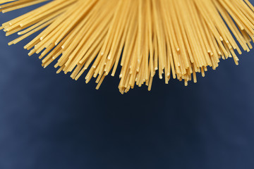Uncooked pasta spaghetti on a blue background