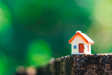 Closeup miniature house on green nature background using as property and family concept