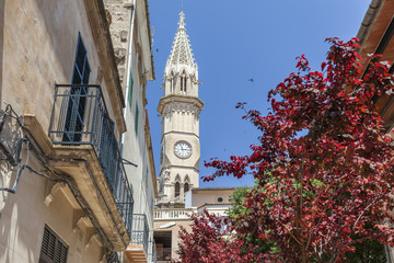 Village view, facade building, flowers and tower church, historic center of Manacor, Mallorca Island, Balearic Islands.Spain.