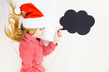 Sleeping woman wearing pajamas and Santa Claus hat