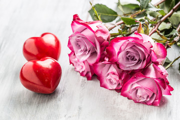 Fototapeta na wymiar Roses. Pink roses with two hearts and red gift.