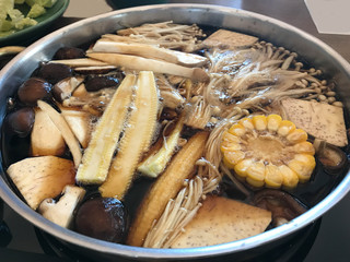 Top view of hot pot shabu shabu with mixed vegetable in black soup