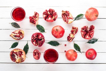 Fresh pomegranate juice. Pomegranate. On a white wooden background. Top view. Copy space.