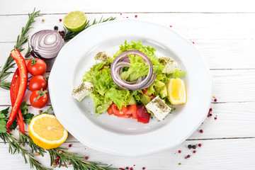 Greek Salad from Fresh Vegetables. On a wooden background. Top view. Copy space.