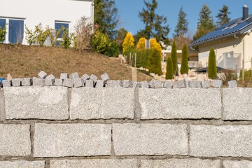 Granit Mauer und viele kleine Granit Pflastersteine 