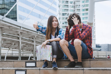 couple young beautiful asian woman and handsome caucasian man seriously between traveling in modern building at big city. travel vacation relax concept.