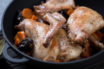 Closeup of rabbit meat stewed in white wine in a cast-iron pan, selective focus, horizontal shot