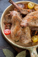 Close-up of stewed rabbit meat with fresh tomatoes in a frying pan, vertical shot, selective focus