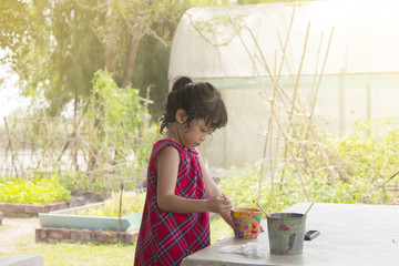 Asian child paint flowers pot on holiday family activity