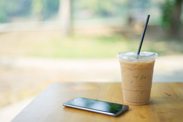Ice coffee with cell phone in garden