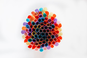 pile of colorful cocktail straws over white background